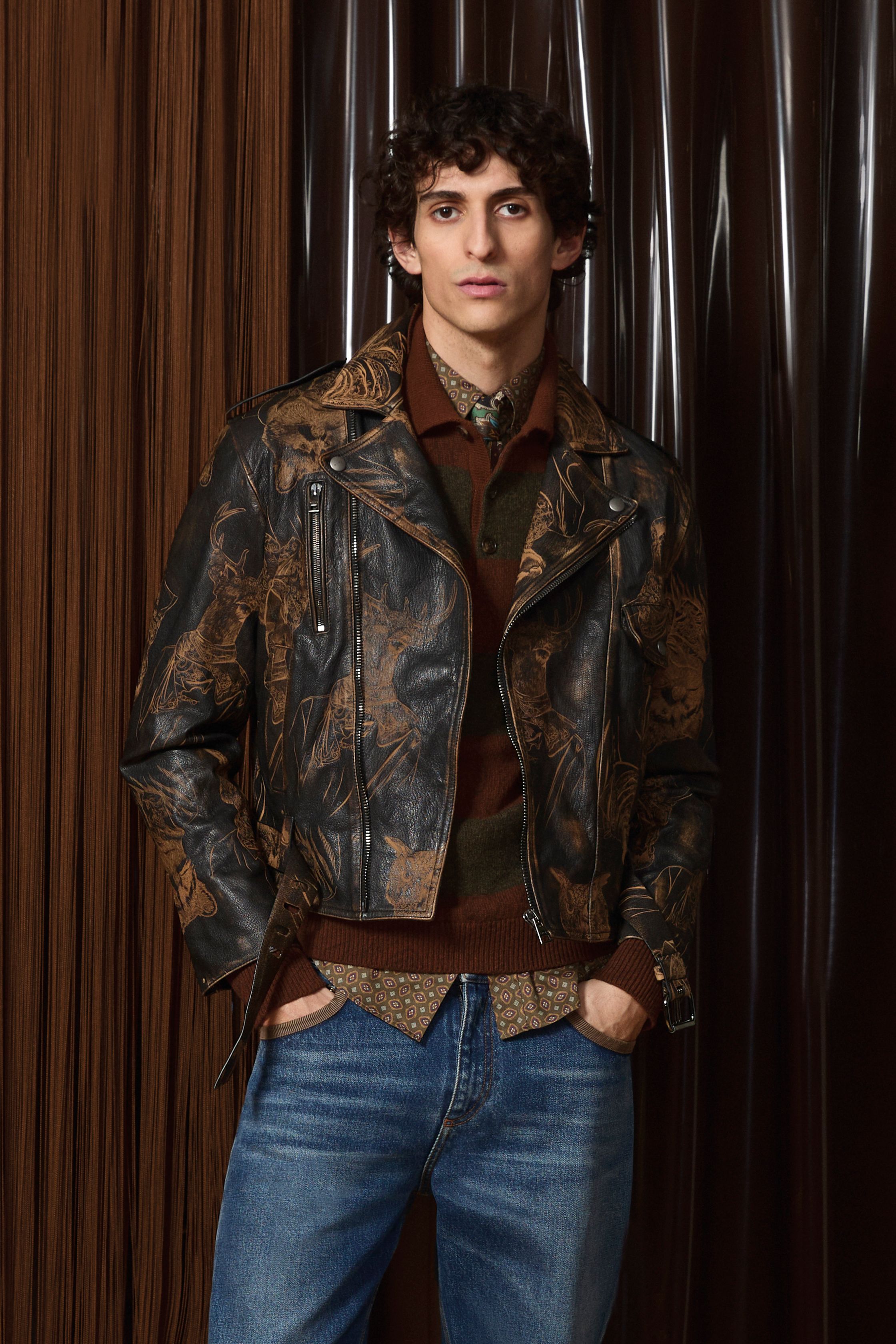 Etro 2026秋冬延续品牌标志性的波西米亚精神，却以更成熟、更男性化的方式呈现。提花针织、佩斯利纹样与复古皮革相互碰撞，营造出知识分子气质与旅行者浪漫并存的形象。整体色调趋向深棕、酒红与森林绿，使装饰性回归内敛，完成一次从“浪漫叙事”到“文化穿着”的进化-顽石频道趋势研究